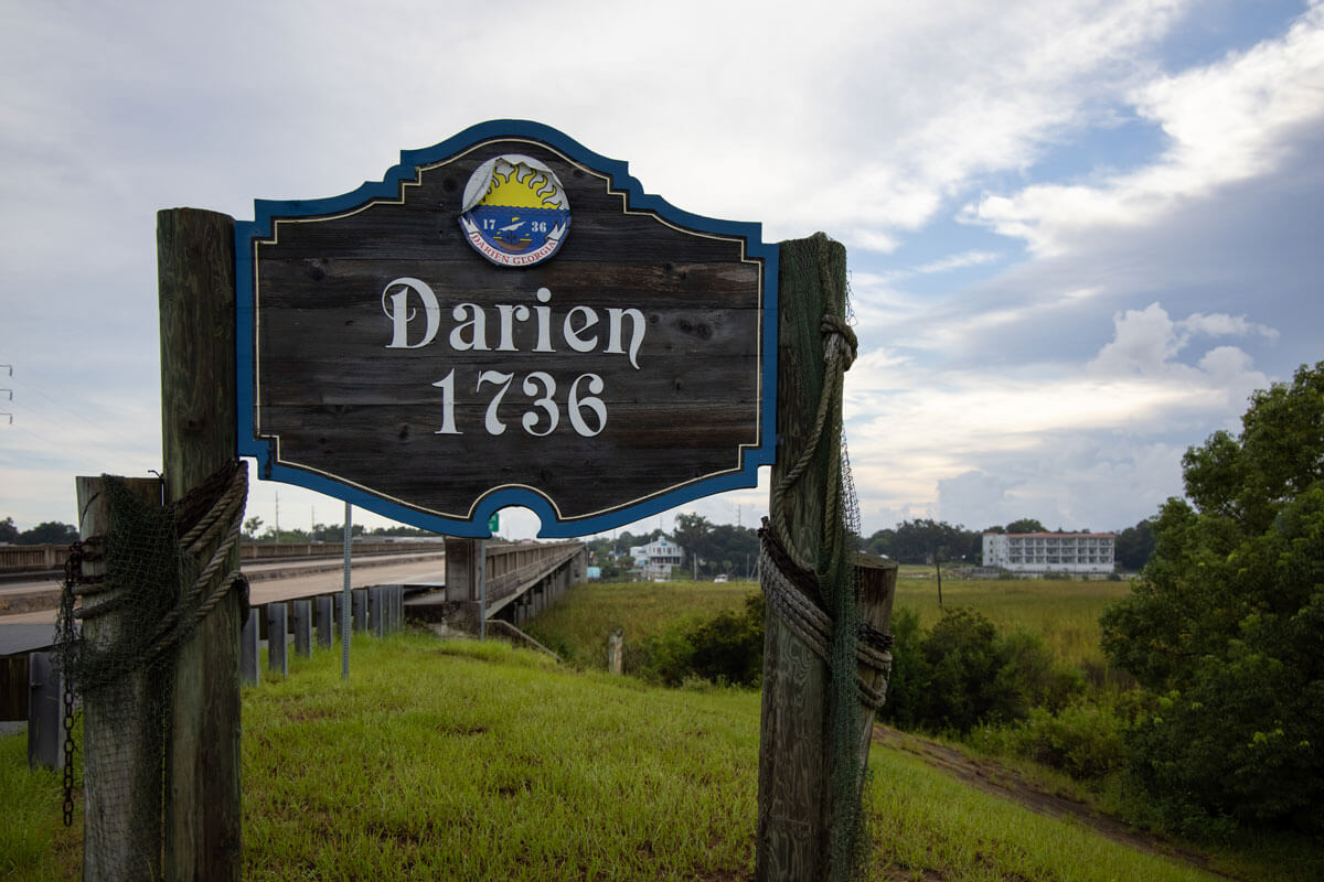 Wooden welcome sign for Darien, Georgia, established 1736, with coastal marsh in the background