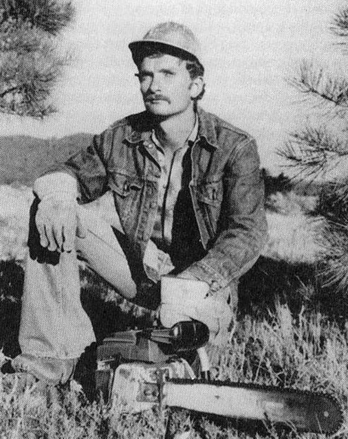 Travis Walton as a young forestry worker, seated outdoors with a chainsaw